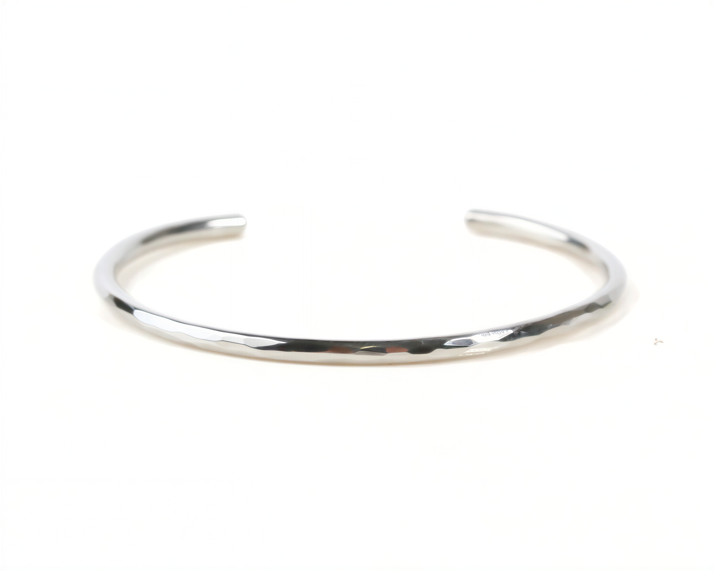 A silver-colored bracelet is shown against a white background.