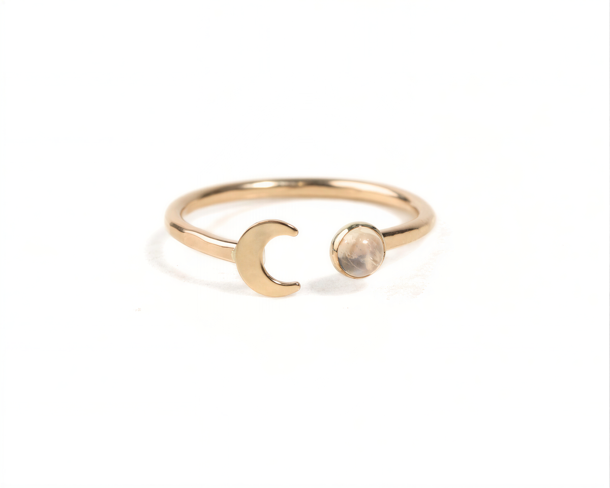 Our Lunara Light Ring displays a dainty crescent moon that sits opposite a small round rainbow moonstone in this open style celestial wraparound ring.