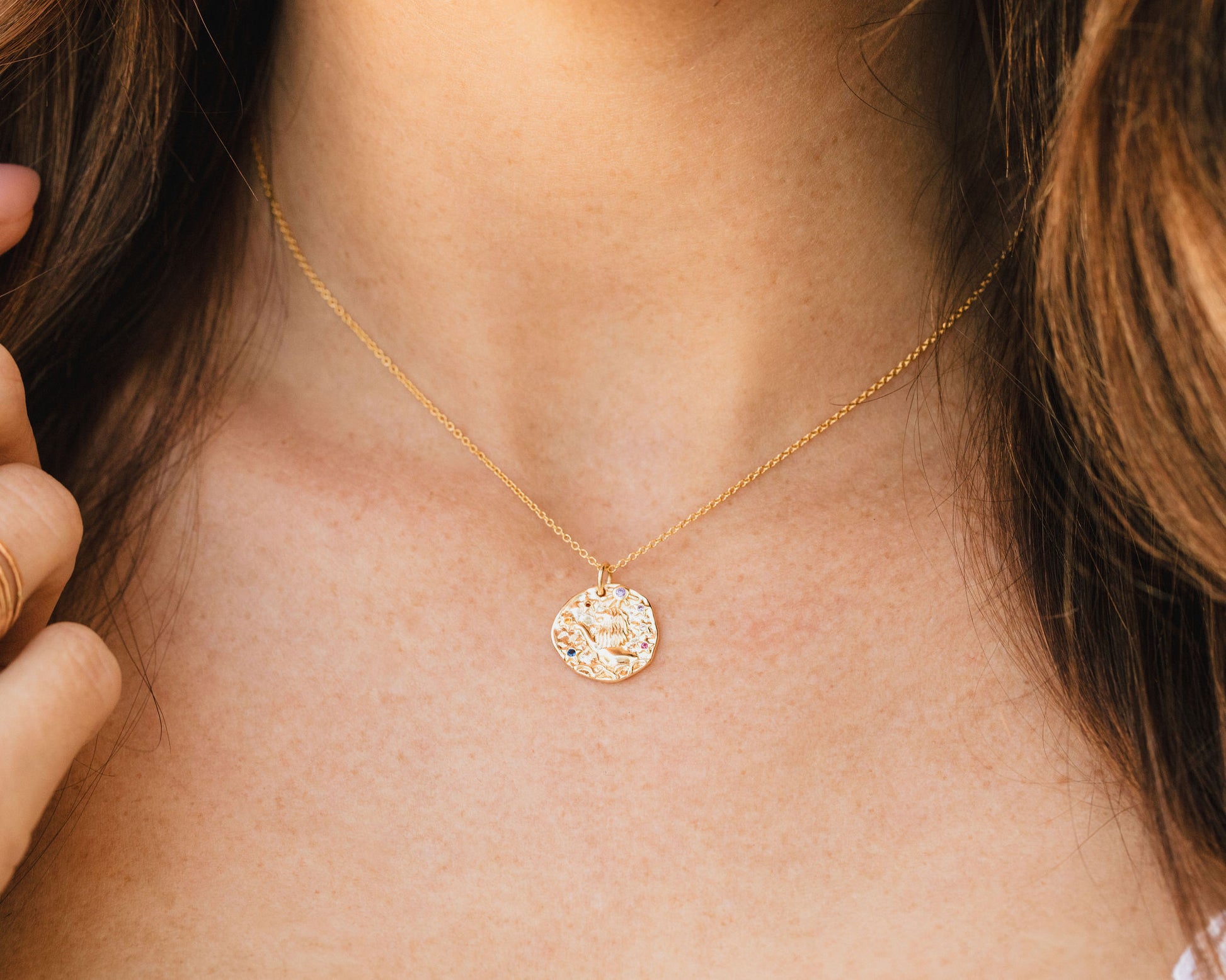 zodiac necklace worn on model