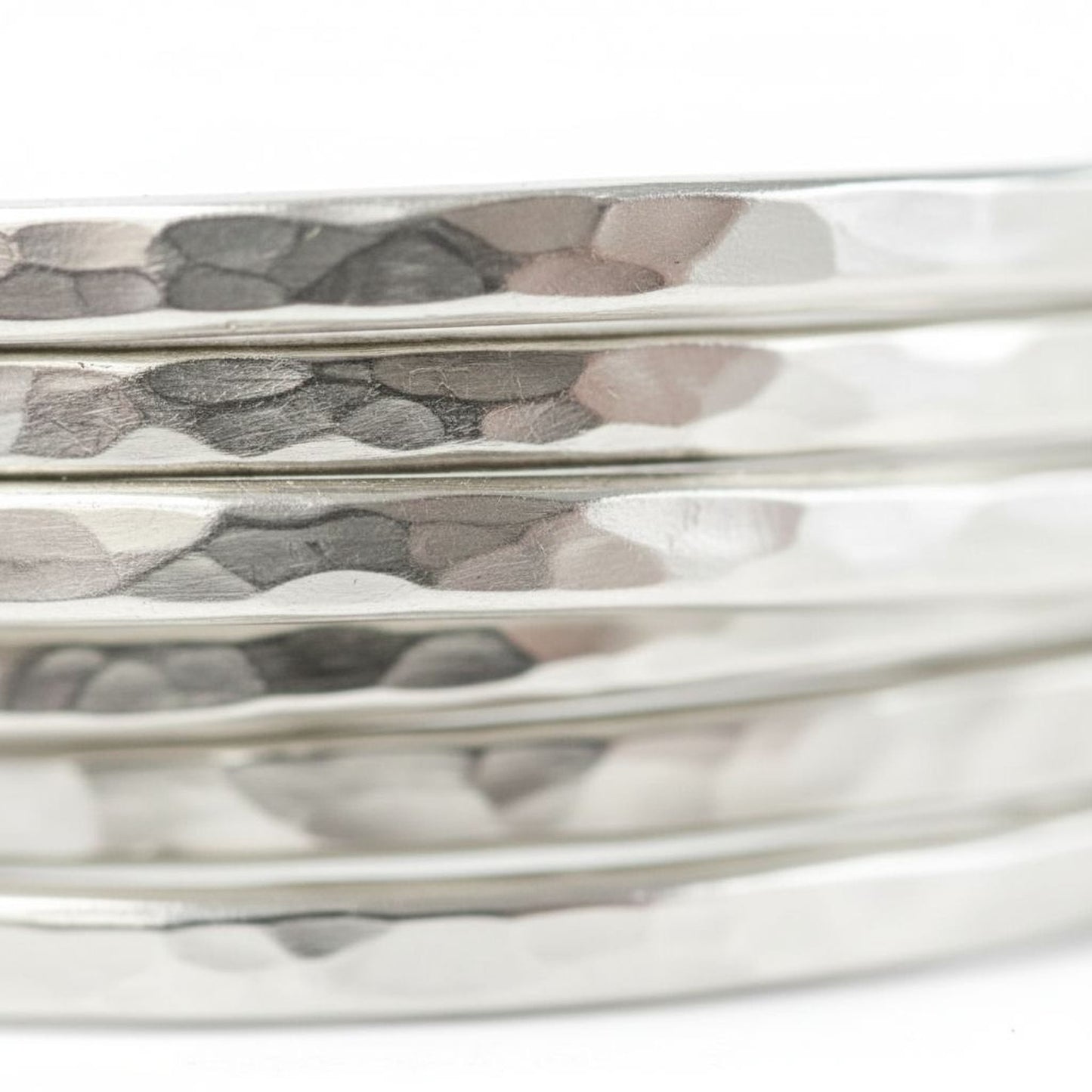 A close-up view of a shiny, metallic bracelet with a textured, embossed surface.