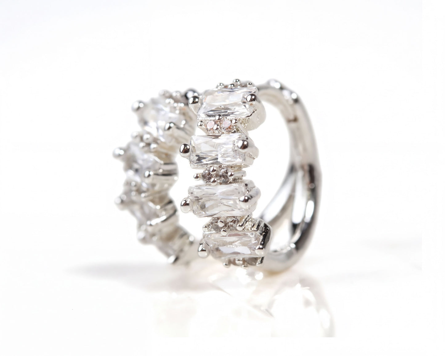 A close-up image of a silver ring with a row of clear gemstones on it.
