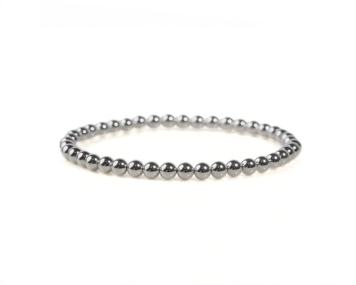 A silver-colored bracelet made of small, shiny beads arranged in a circular pattern.