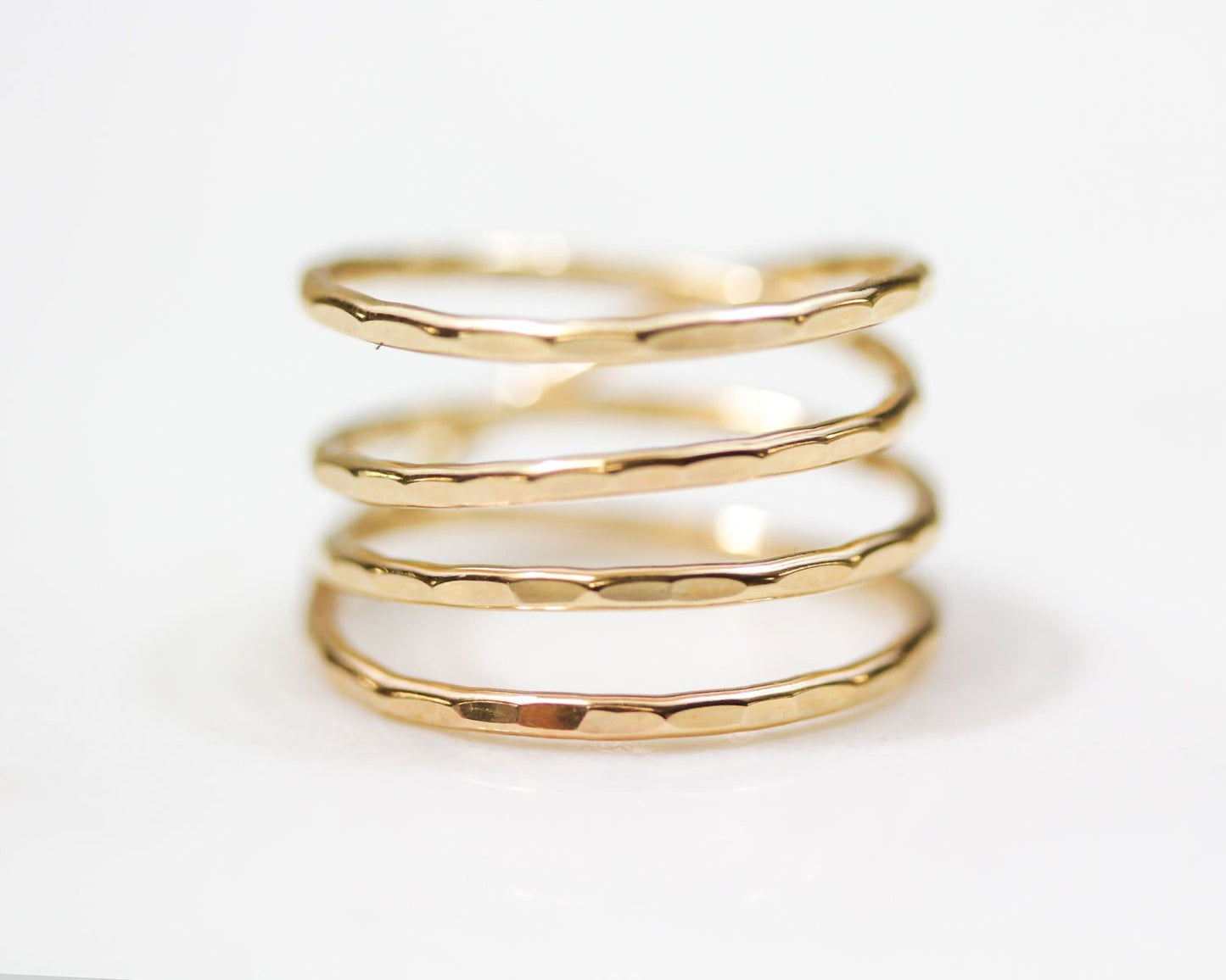 A close-up image of a gold ring with a spiral design, showcasing the intricate details and craftsmanship of the piece.