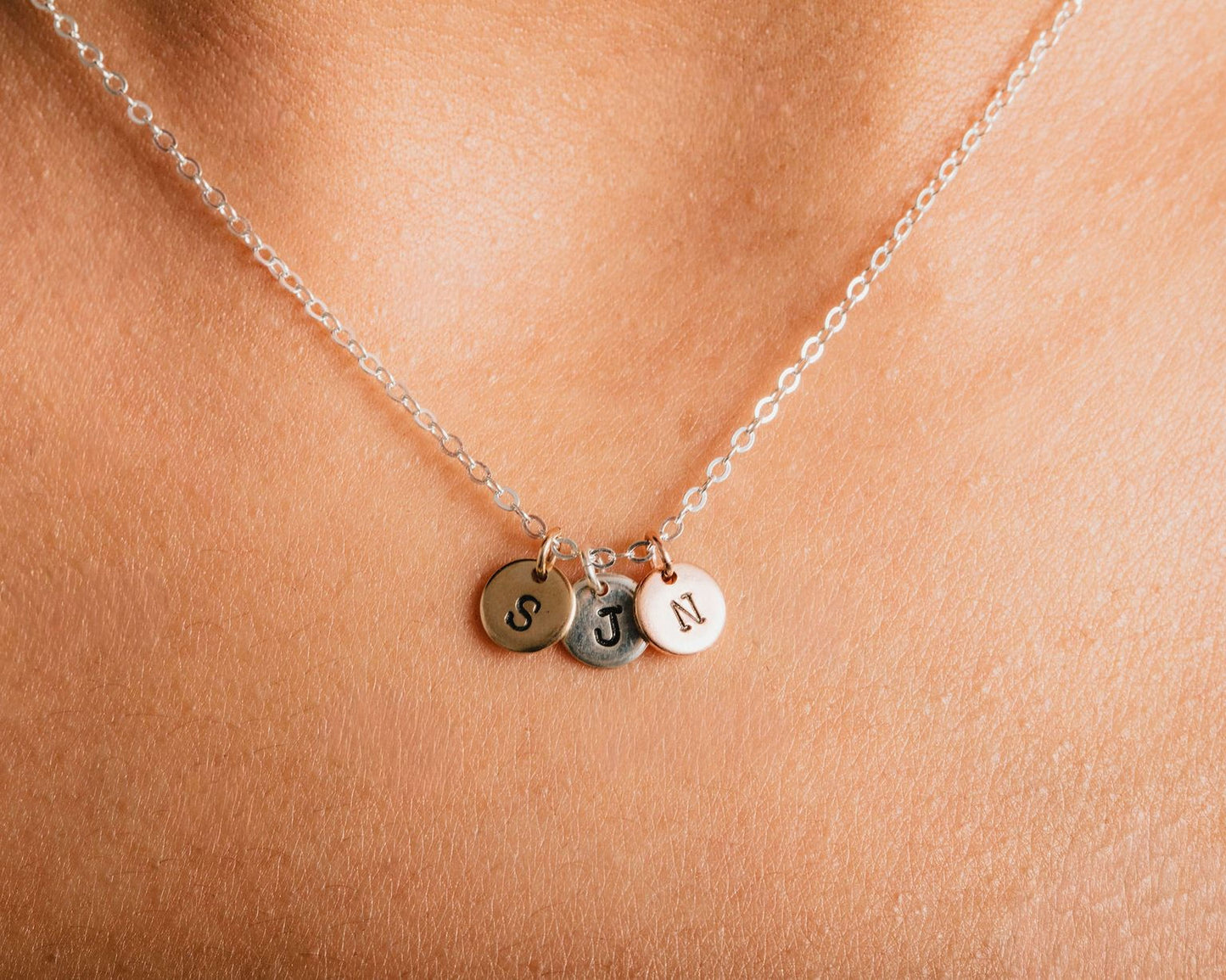 A necklace with three small charms hanging from it.