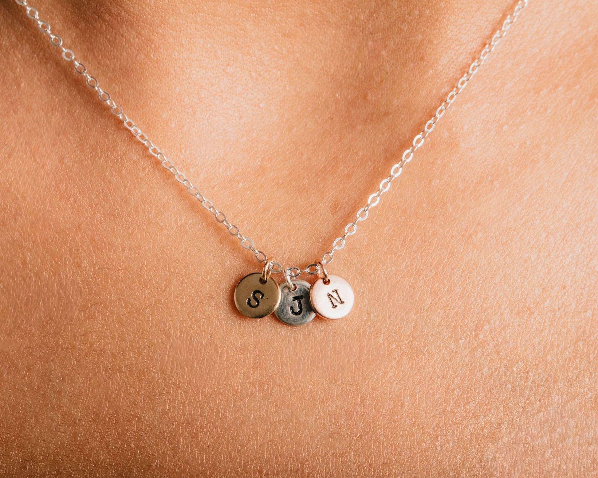 A necklace with three small charms hanging from it.