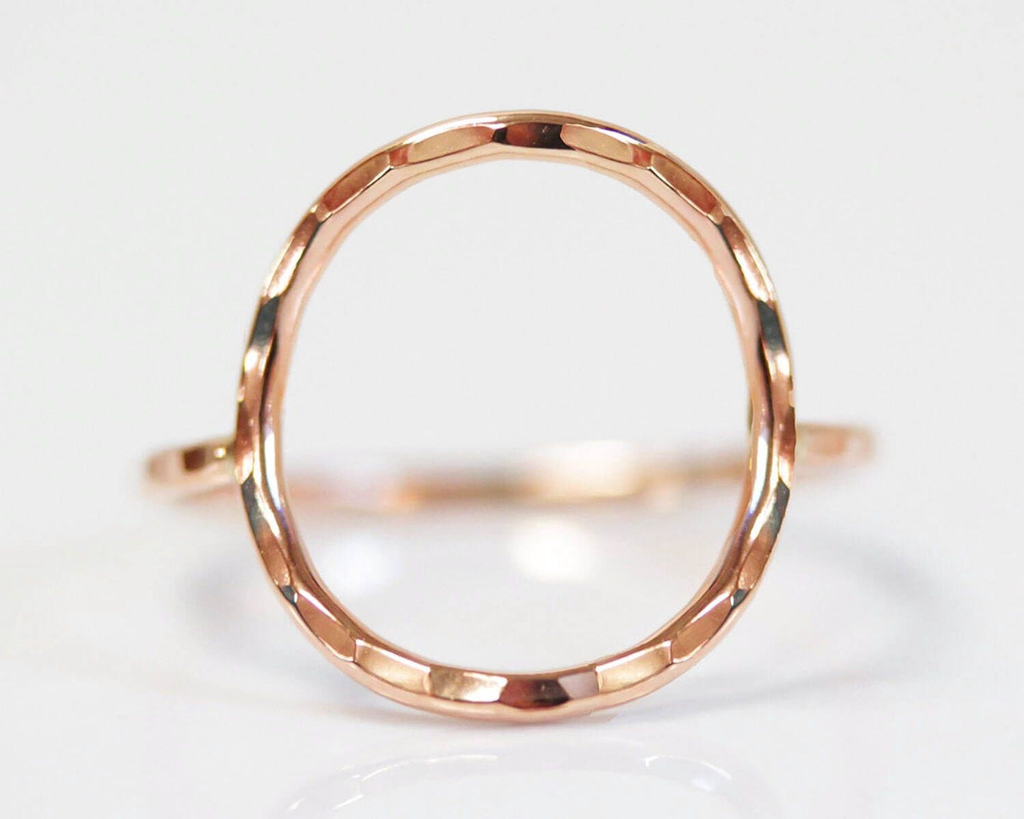 A close-up image of a gold-colored ring with a textured, circular design.