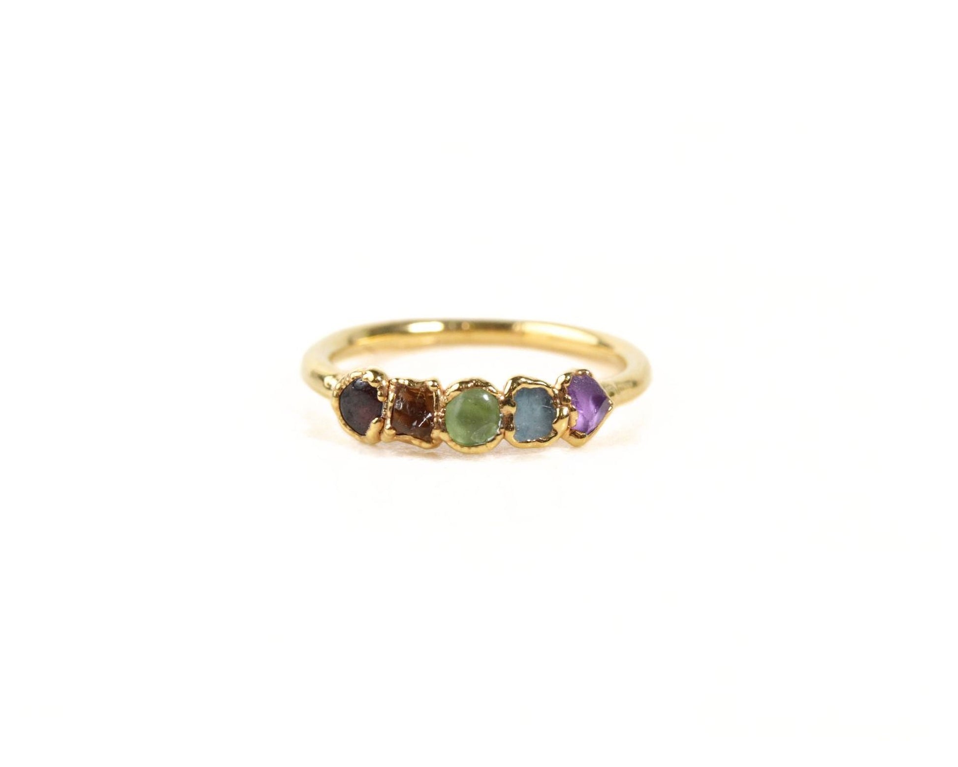 A gold ring with a row of colorful gemstones on it.