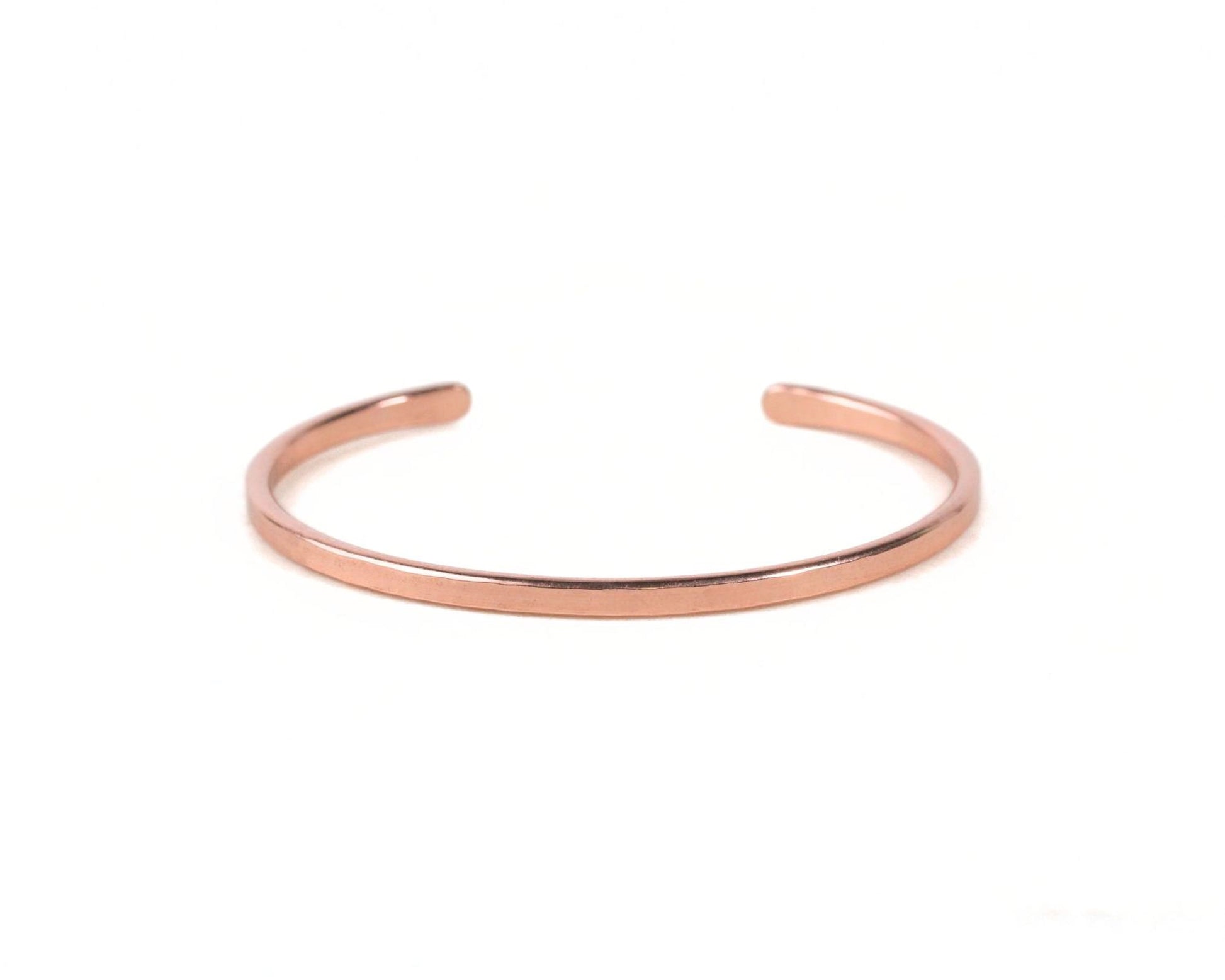 A copper-colored bracelet is shown against a white background.