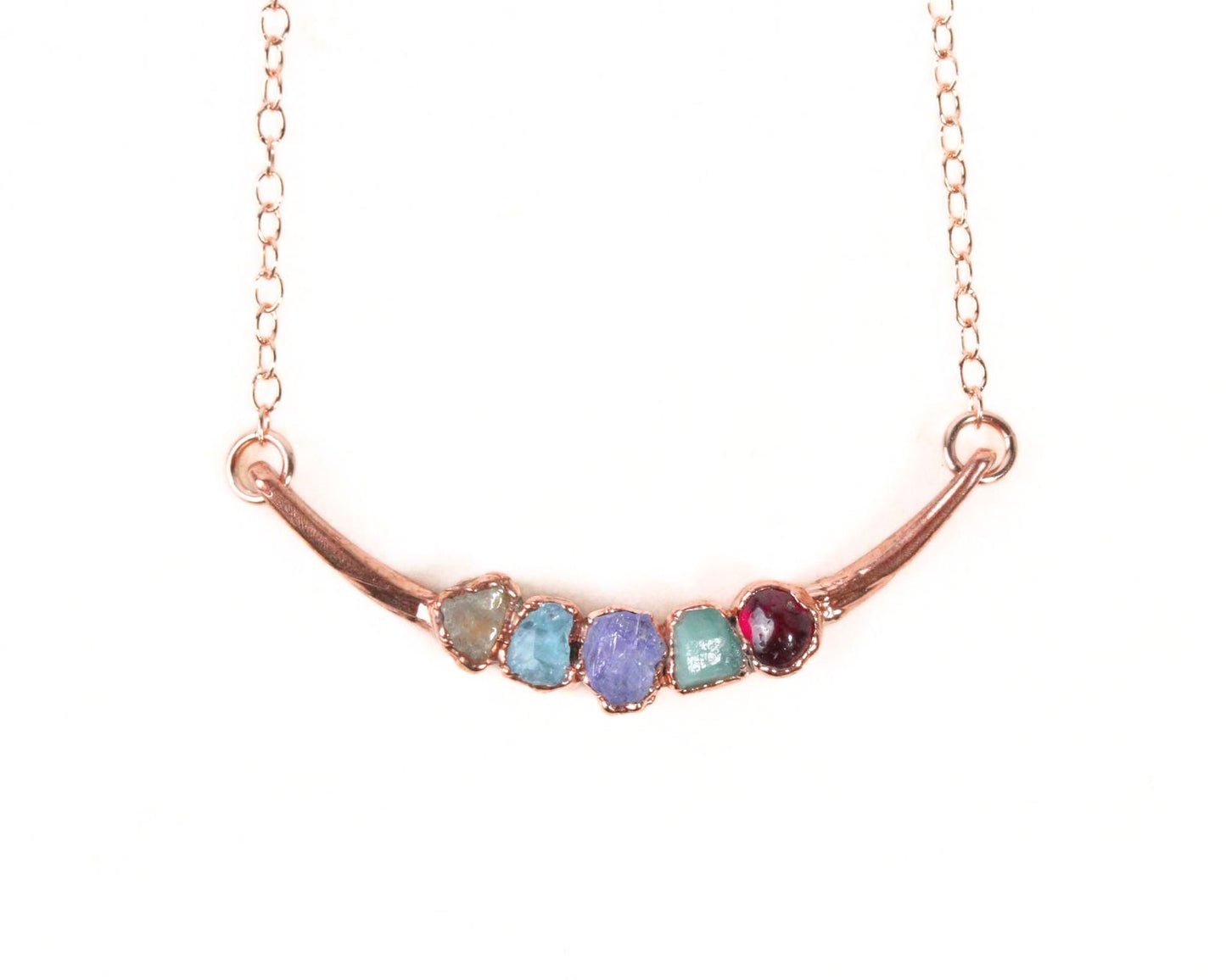 A necklace with a curved metal bar and five colorful gemstones on it.