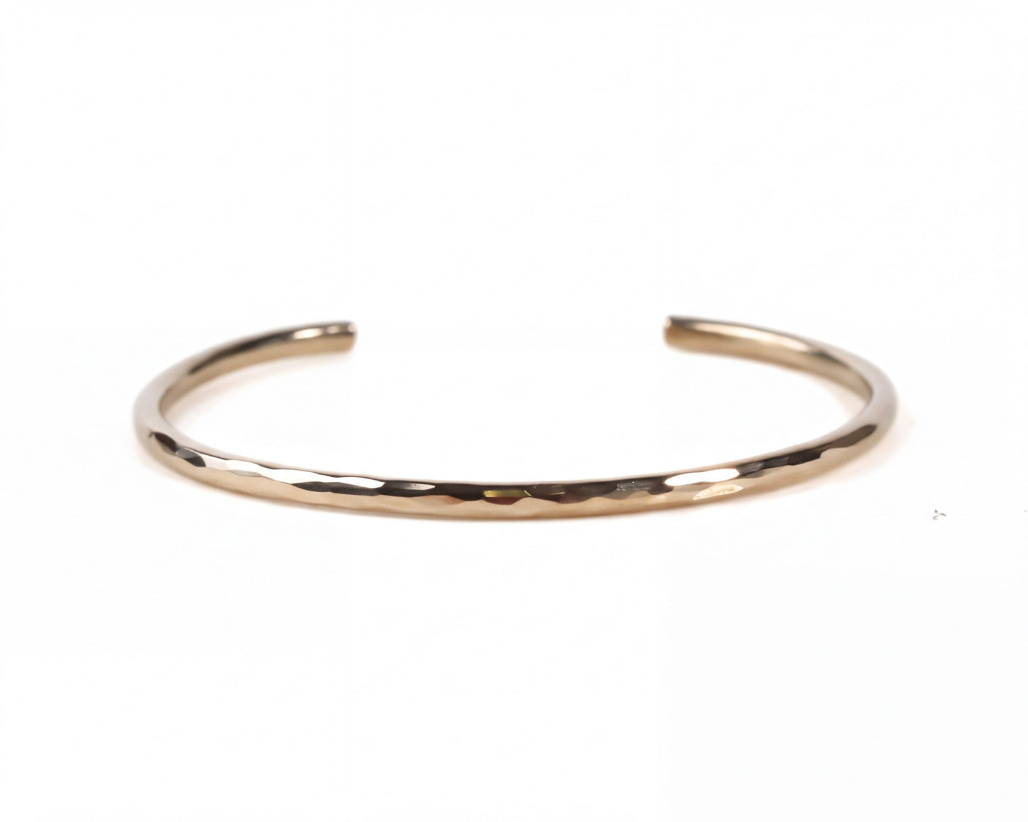 A simple, gold-colored bracelet with a smooth, shiny texture.