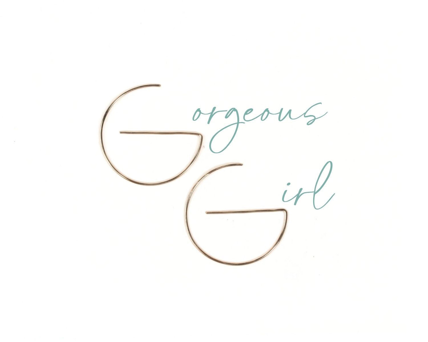 a pair of gold-colored earrings with the text "Gorgeous girl" written in cursive above them.