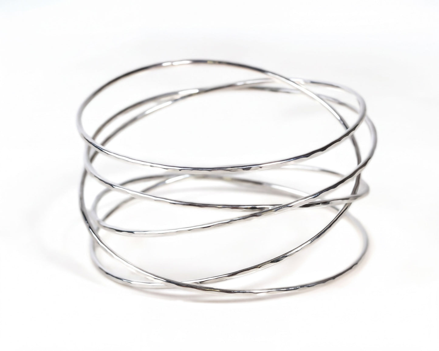 A silver wire bracelet with multiple concentric circles of varying thicknesses, creating a visually interesting and textured design.