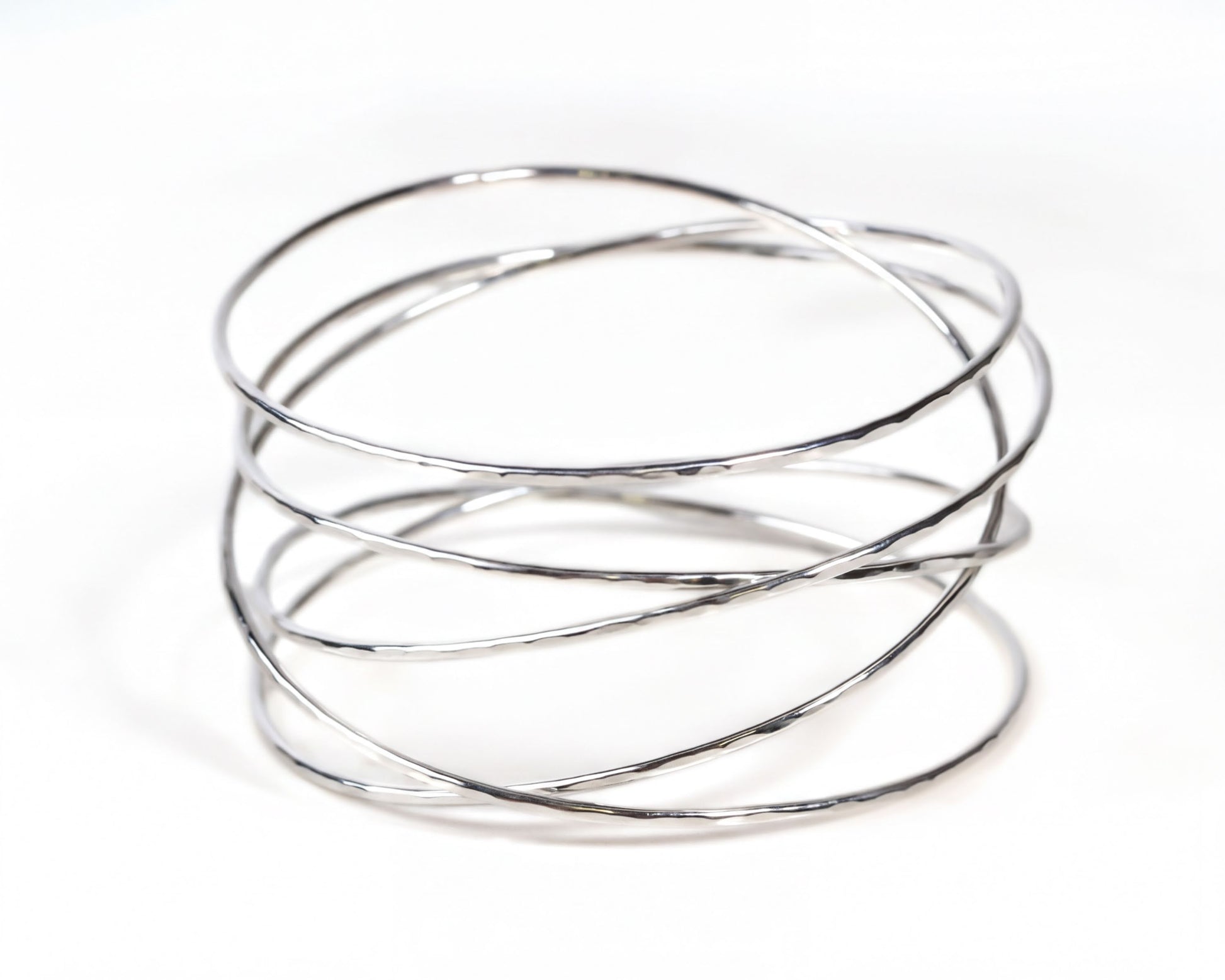 A silver wire bracelet with multiple concentric circles of varying thicknesses, creating a visually interesting and textured design.