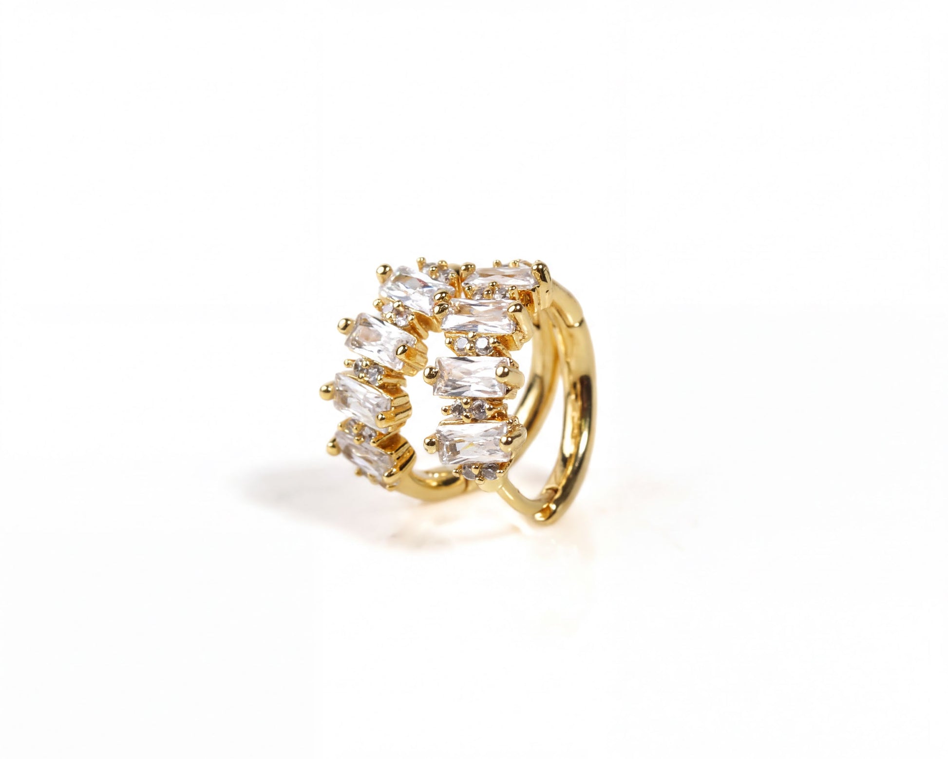 A gold earring with a decorative design of small, clear gemstones.