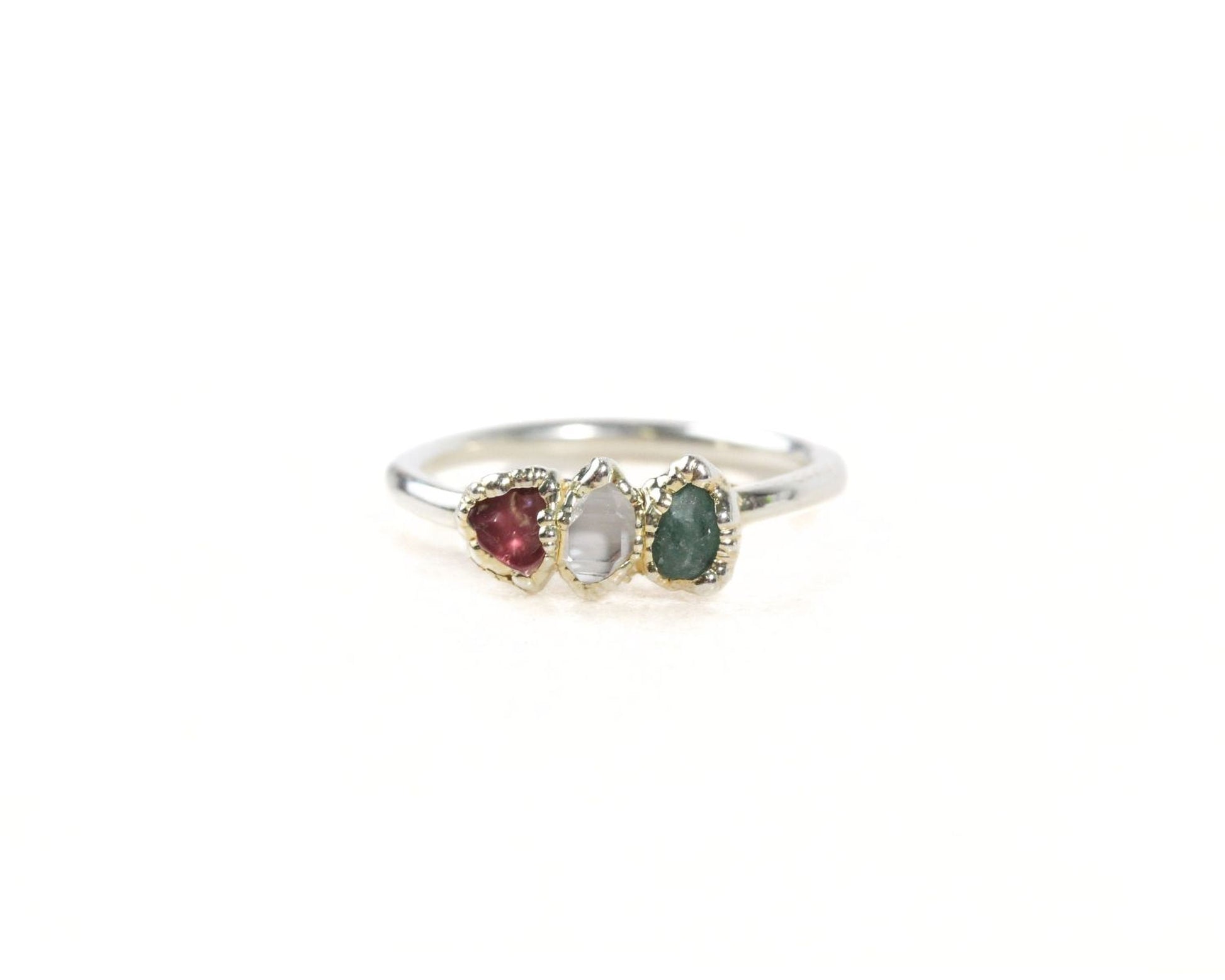 A silver ring with three gemstones on it.