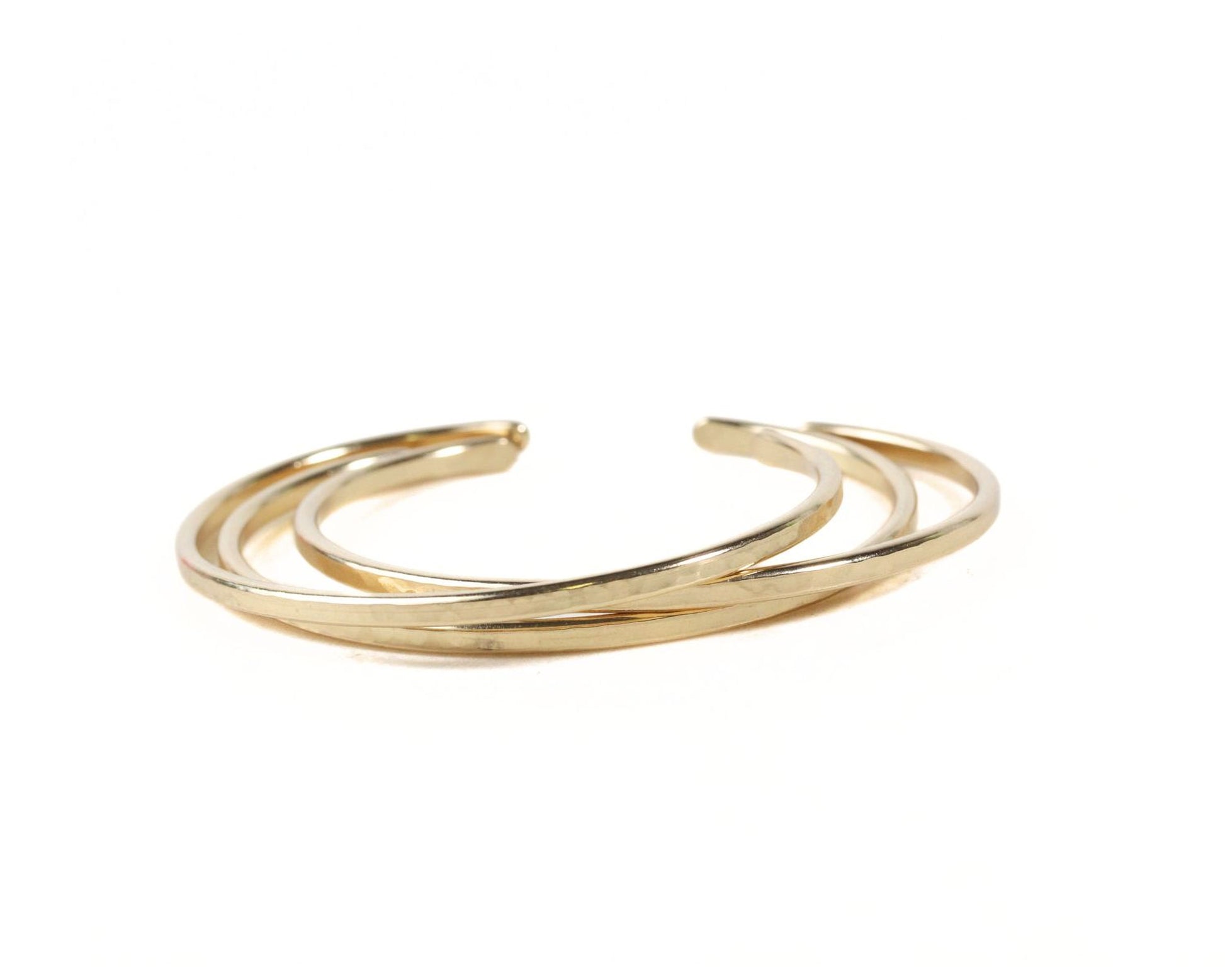 A gold-colored bracelet with three overlapping rings.