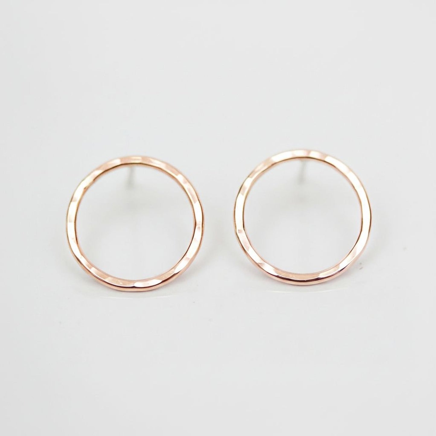 A pair of simple, elegant earrings with a round, metallic design.
