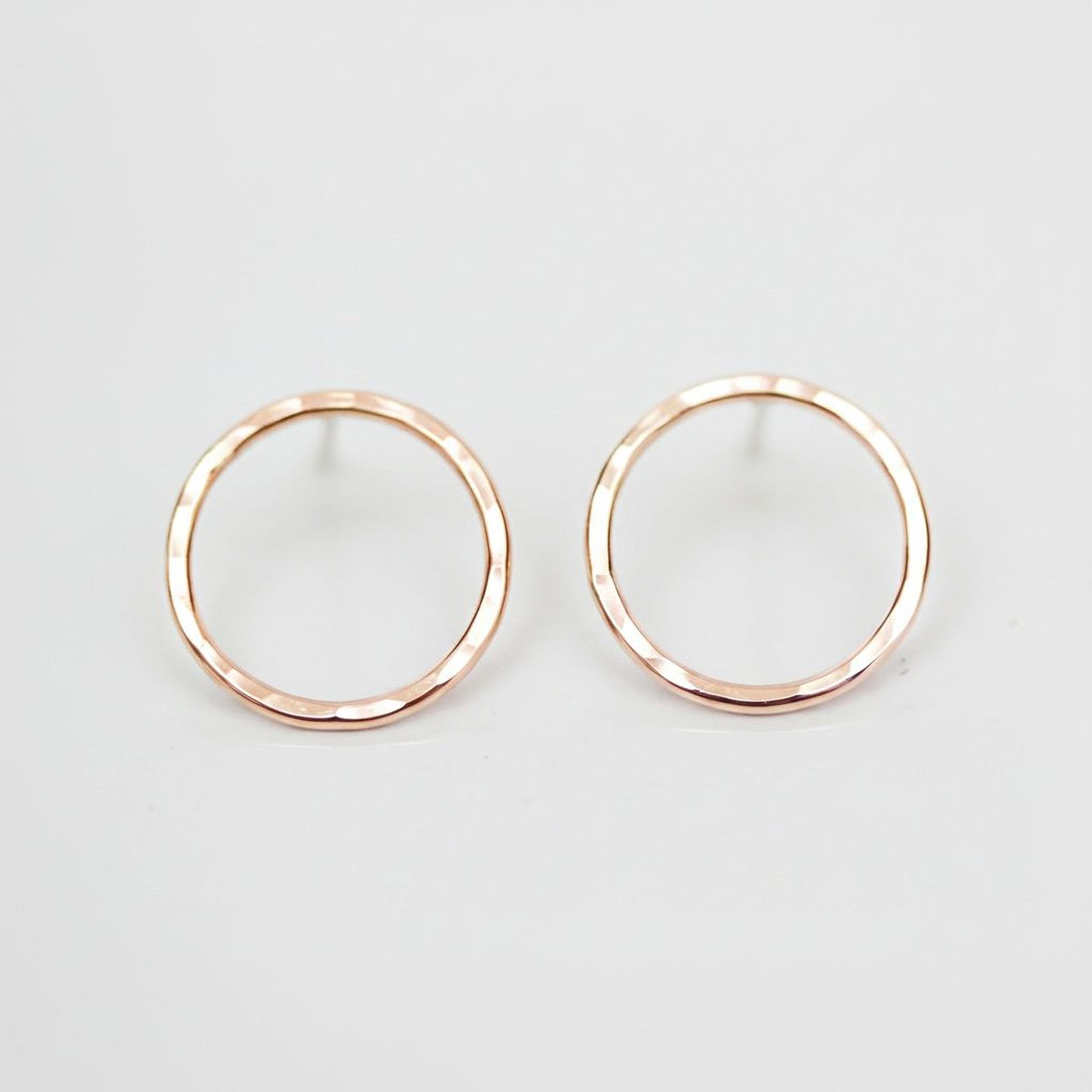 A pair of simple, elegant earrings with a round, metallic design.
