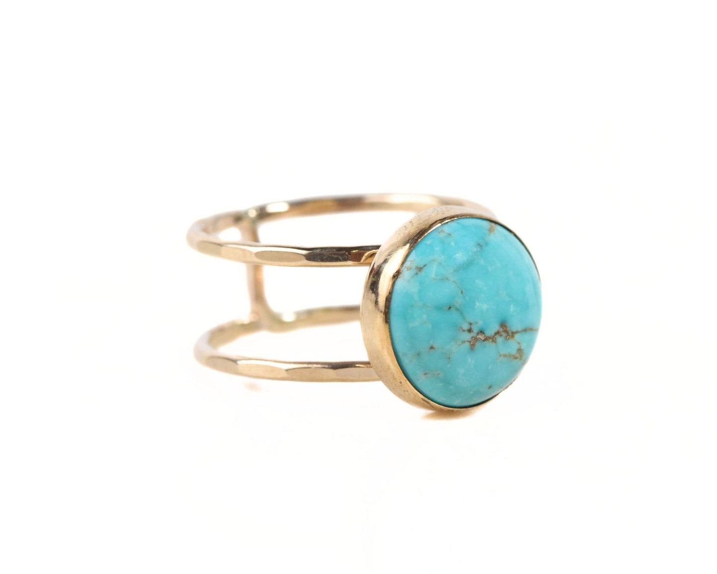 A gold ring with a turquoise stone set in the center.