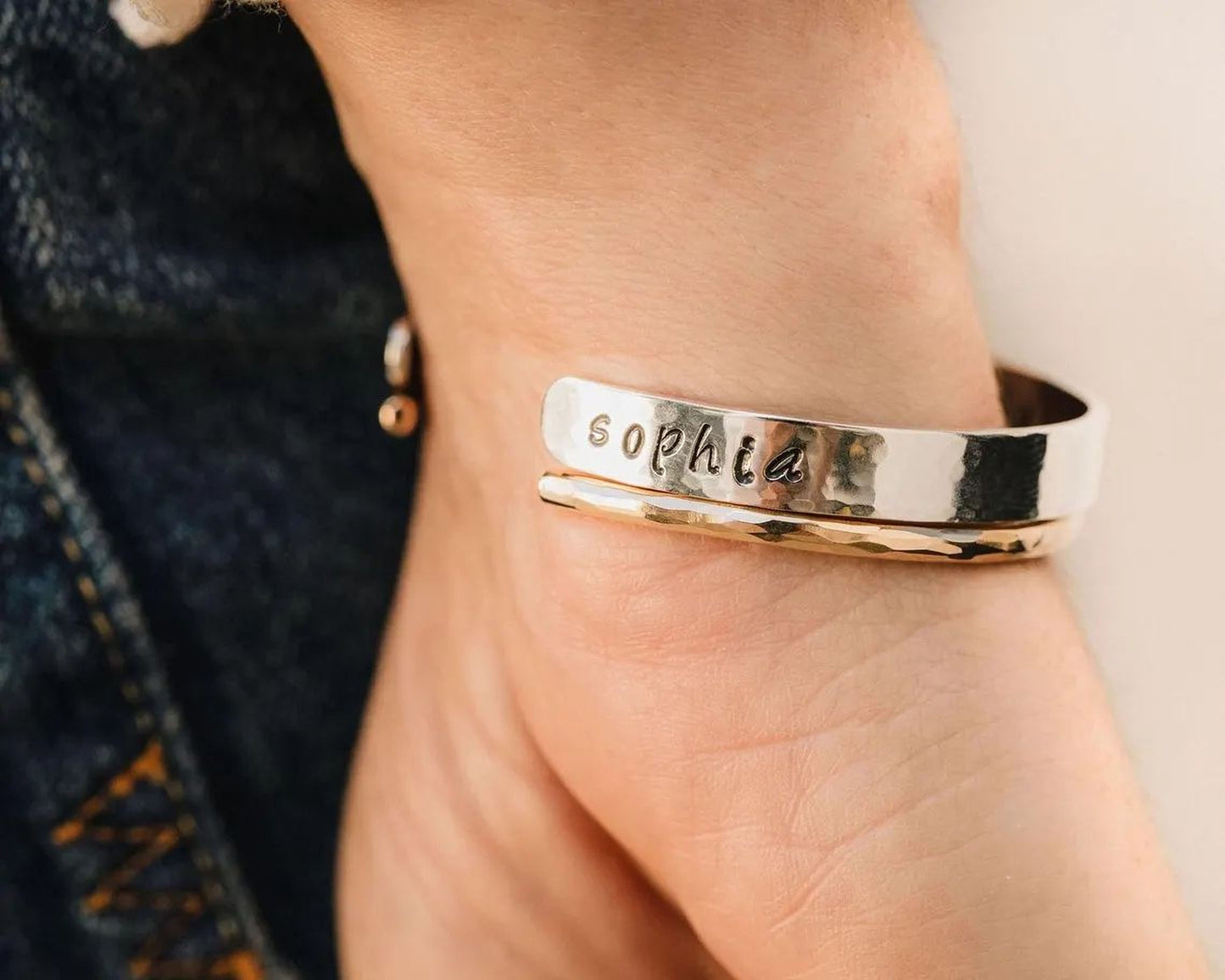 A close-up of a person's wrist wearing a bracelet with the name "Sophia" engraved on it.