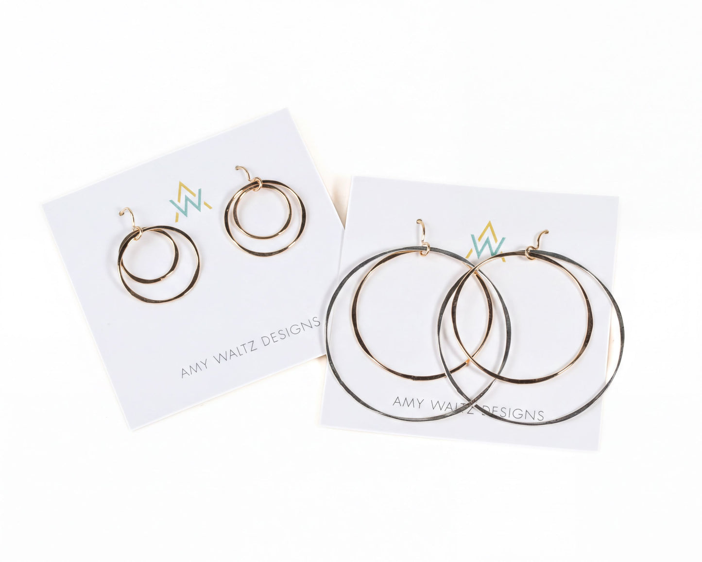 a pair of earrings from the brand Amy Waitz Designs, featuring a unique design with three concentric circles of varying sizes.
