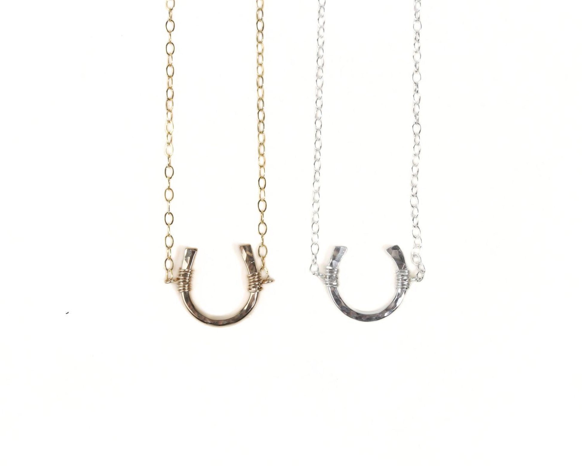 Two necklaces with a horseshoe-shaped pendant are shown against a white background.