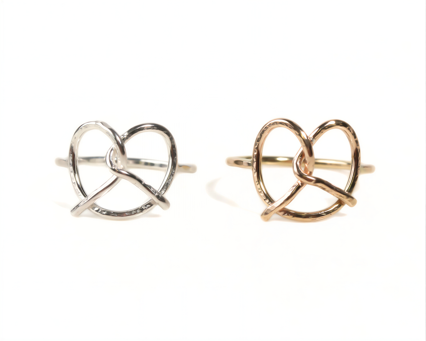 Two rings with heart-shaped designs, one silver and one gold.