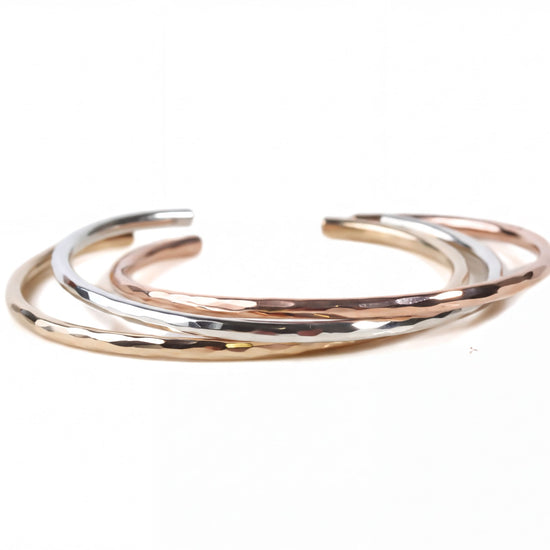 A group of three bracelets with different colors and textures, arranged in a circular pattern.