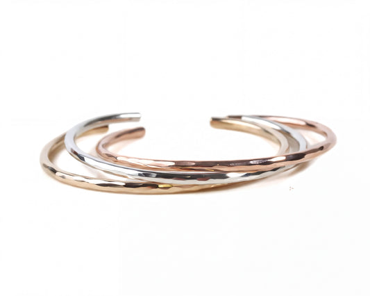 A group of three bracelets with different colors and textures, arranged in a circular pattern.