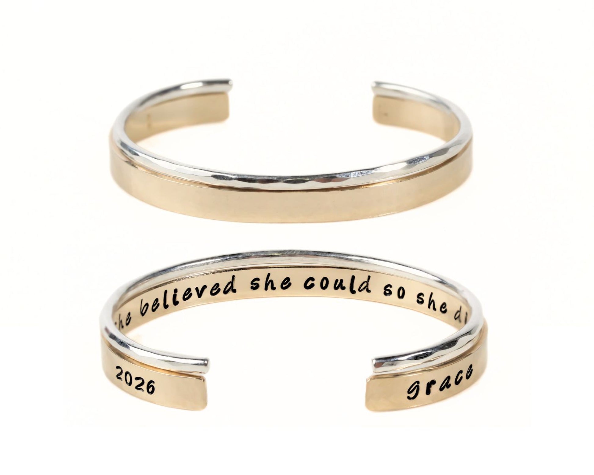 A gold-colored bracelet with a text engraved on it.