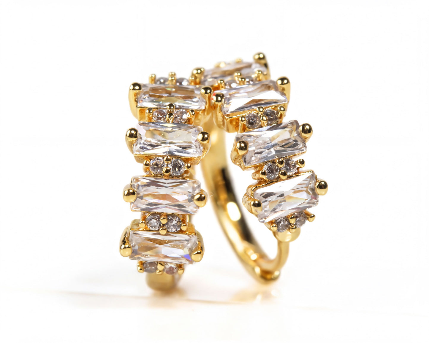 A gold ring with a unique design featuring a series of rectangular gemstones arranged in a curved pattern.
