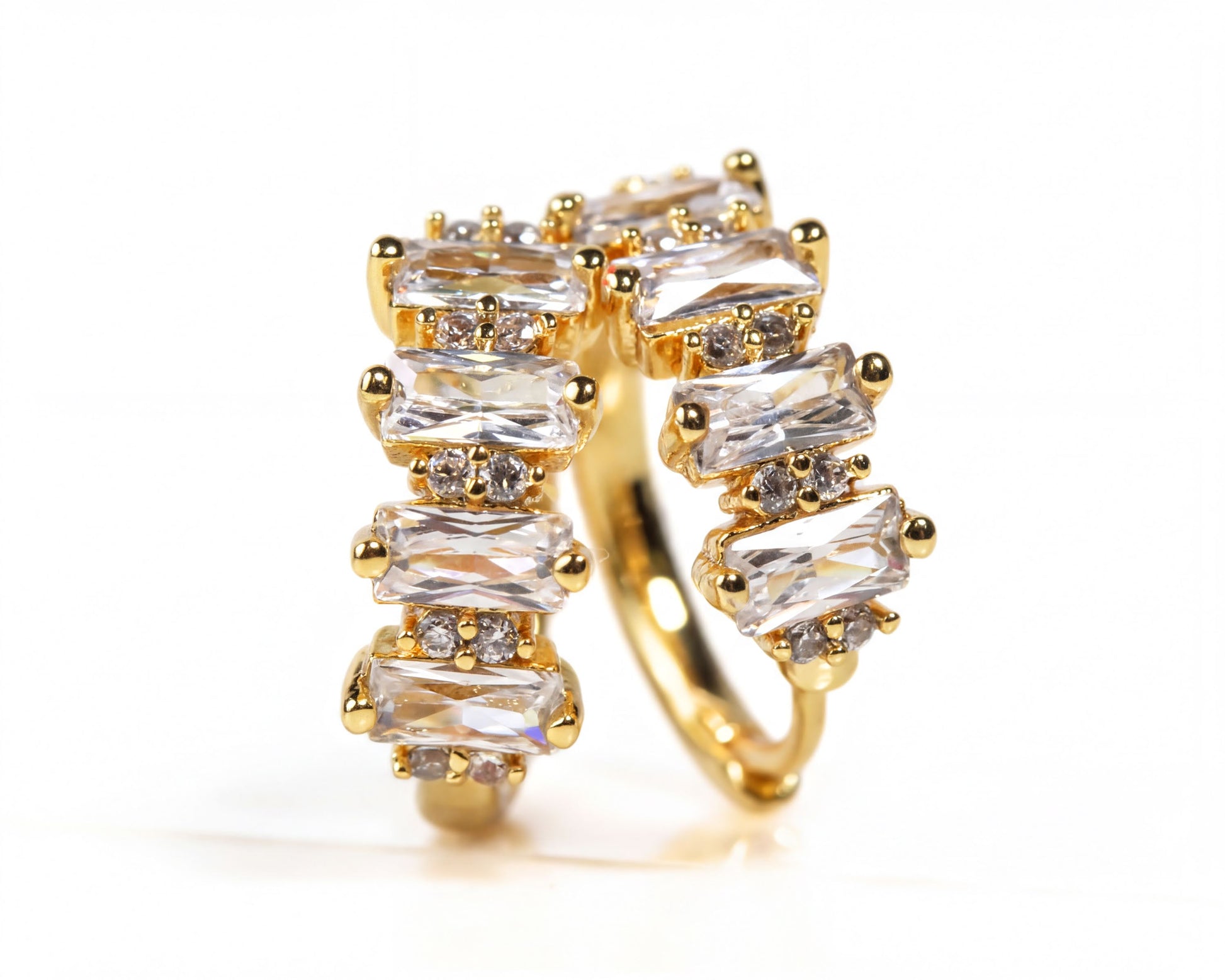 A gold ring with a unique design featuring a series of rectangular gemstones arranged in a curved pattern.