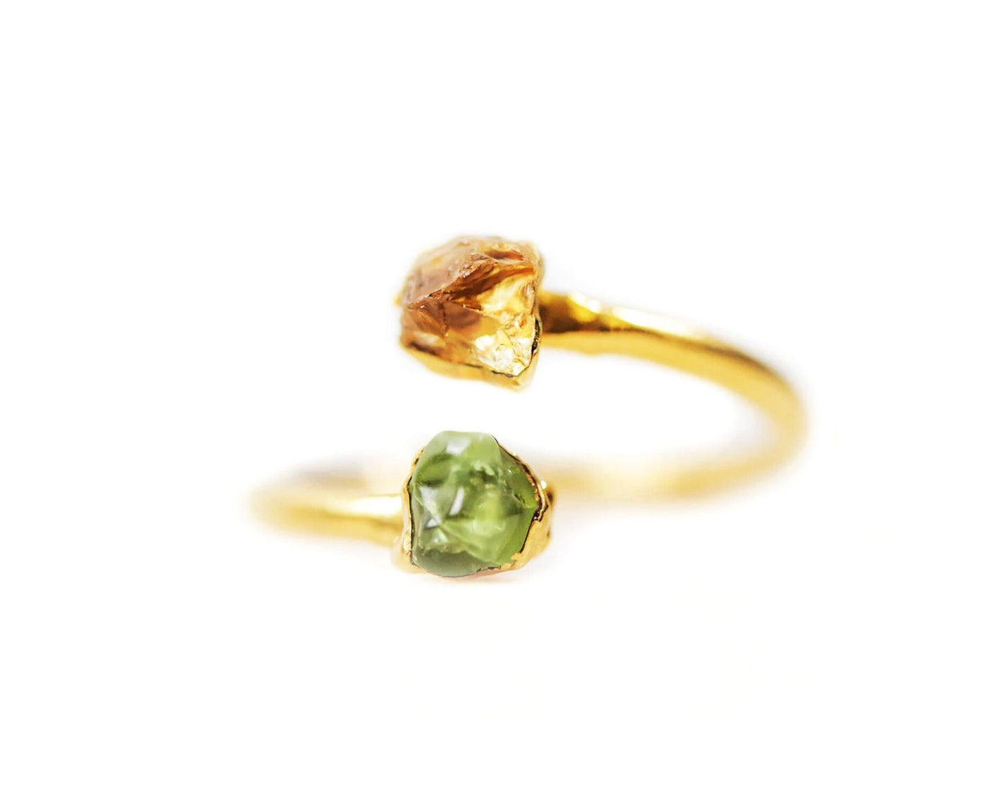 A gold ring with two gemstones, one green and one yellow, set in the center.