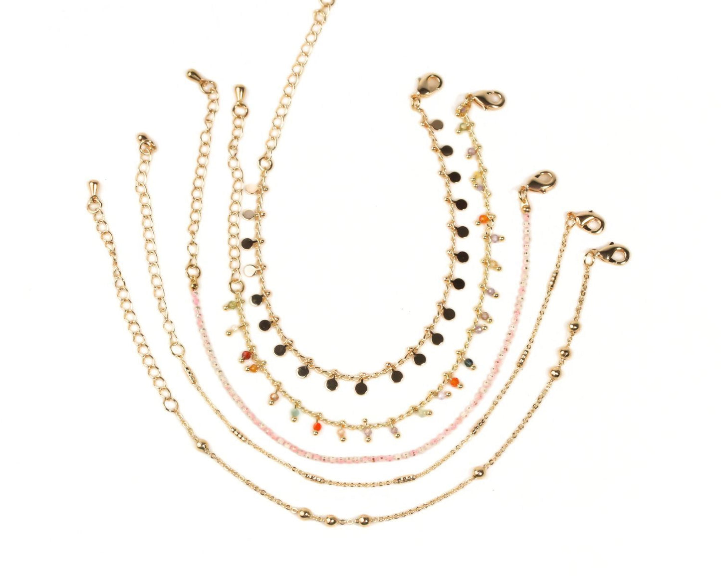 A collection of gold-colored beaded bracelets with various designs and colors, arranged in a circular pattern.