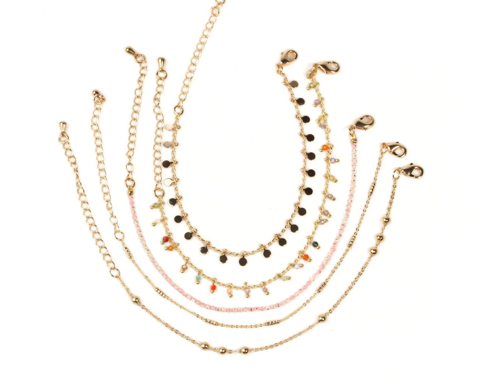 A collection of gold-colored beaded bracelets with various designs and colors, arranged in a circular pattern.
