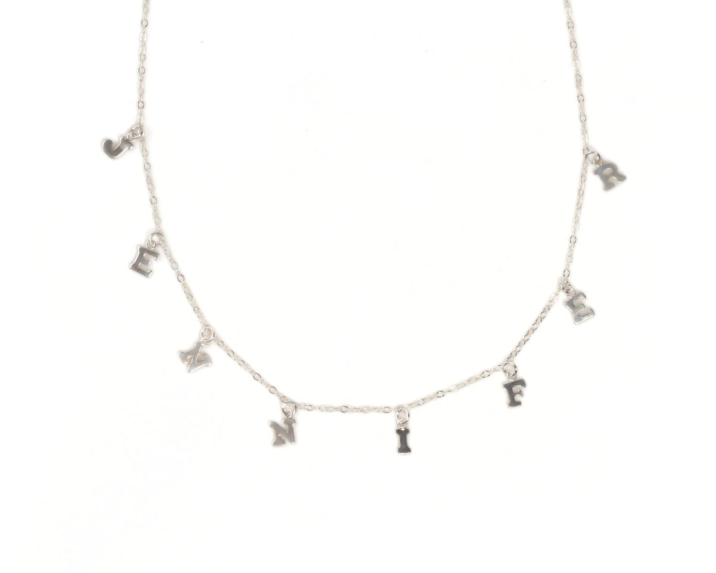 A necklace with a series of small silver charms hanging from it, each containing a letter of the alphabet.