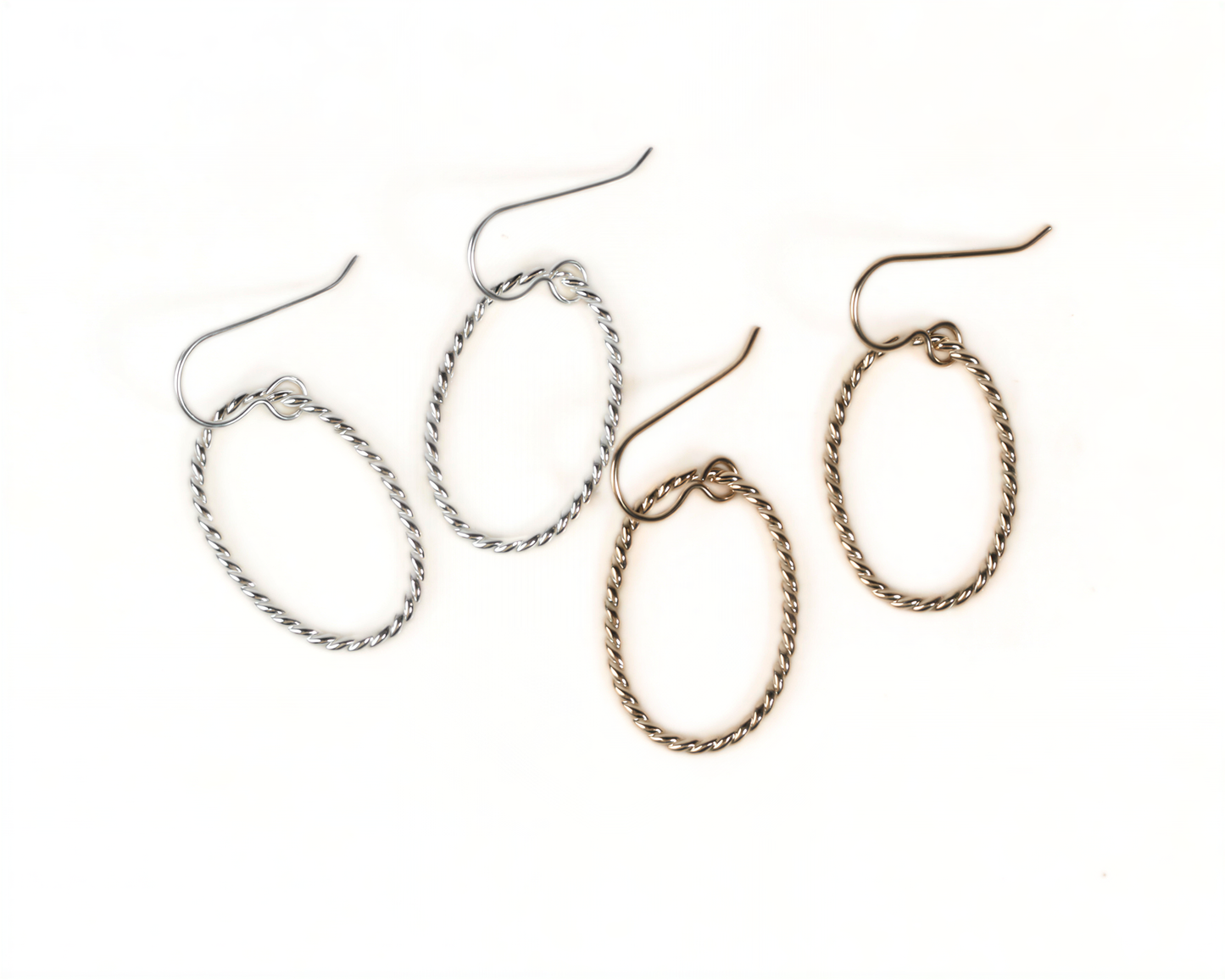 a pair of earrings with twisted metal designs, featuring two pairs of earrings in different colors.