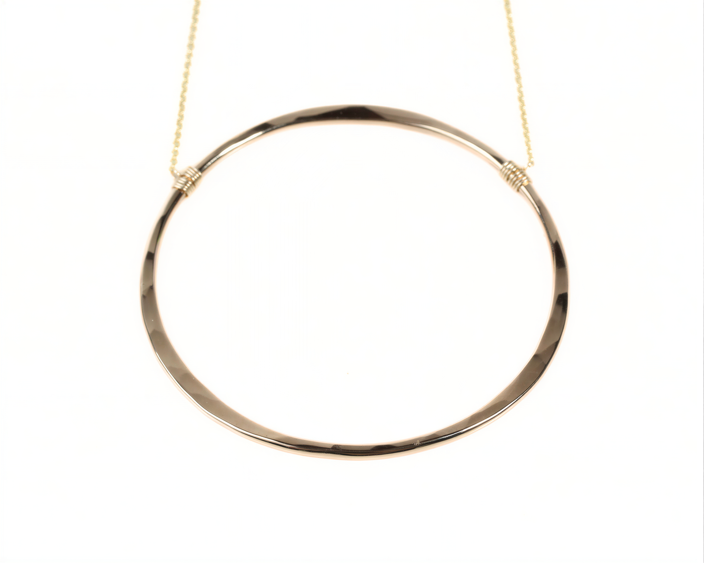 A gold-colored circular necklace with a smooth, shiny finish.