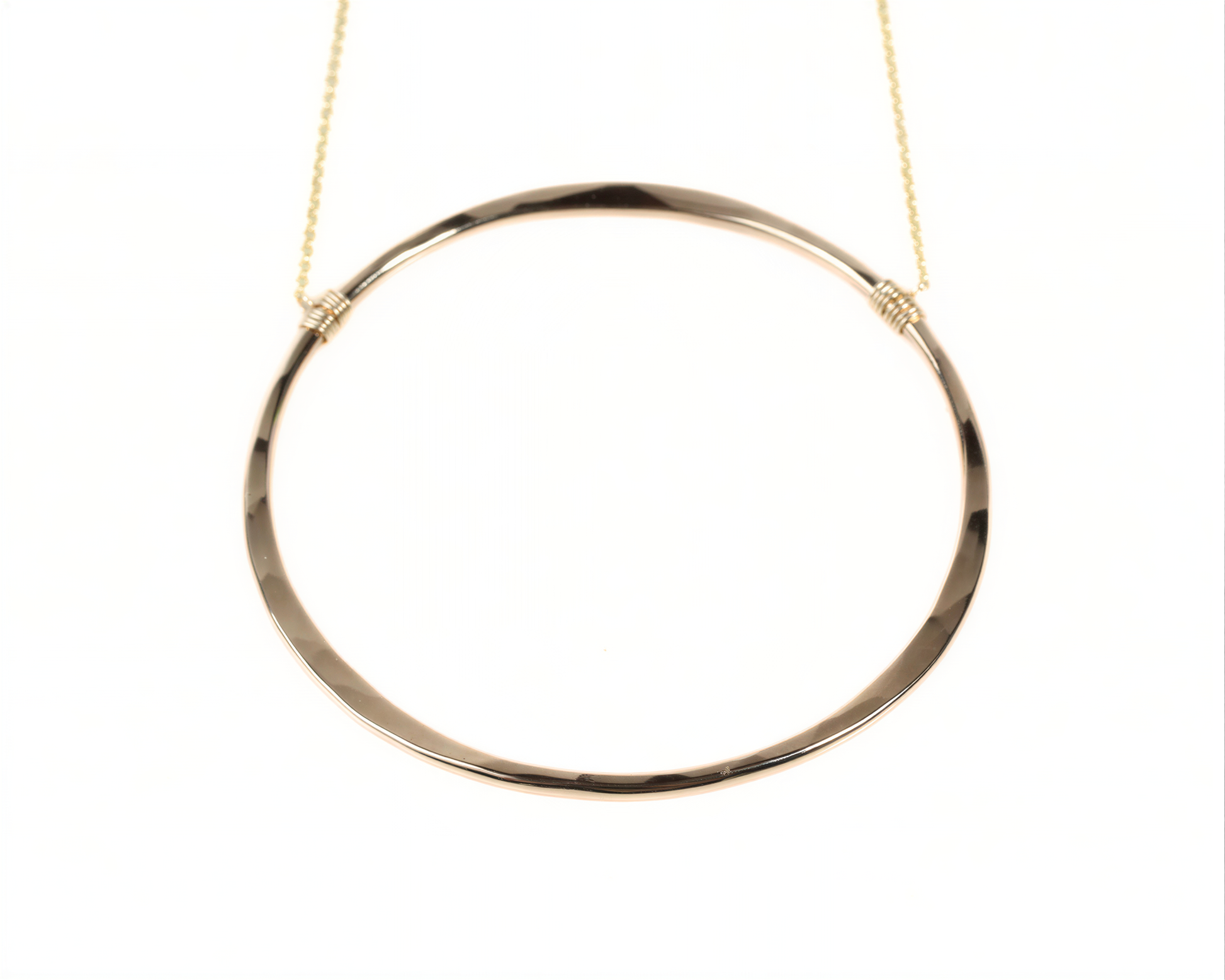 A gold-colored circular necklace with a smooth, shiny finish.