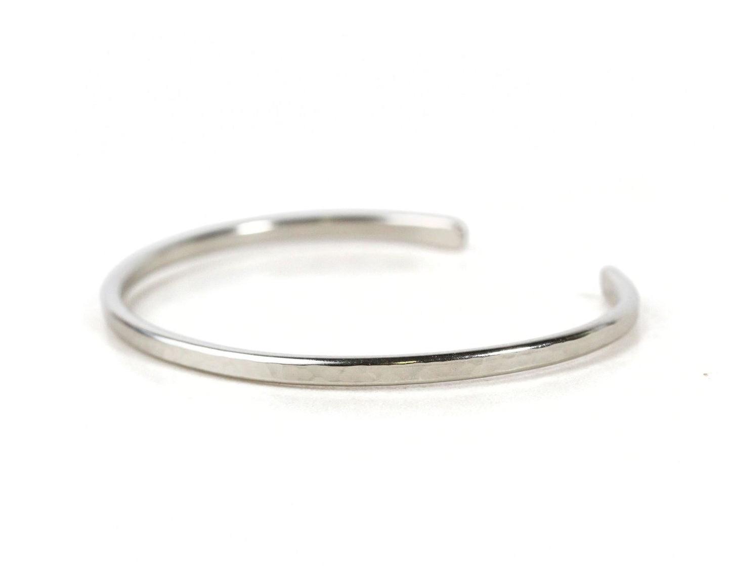 A silver-colored bracelet with a curved design.