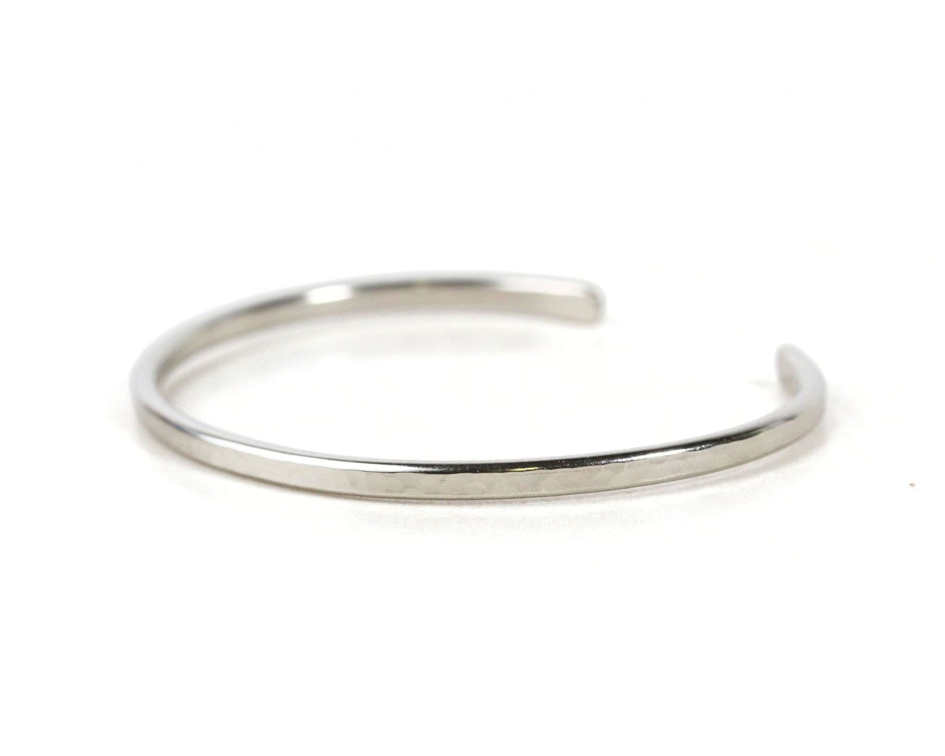 A silver-colored bracelet with a curved design.