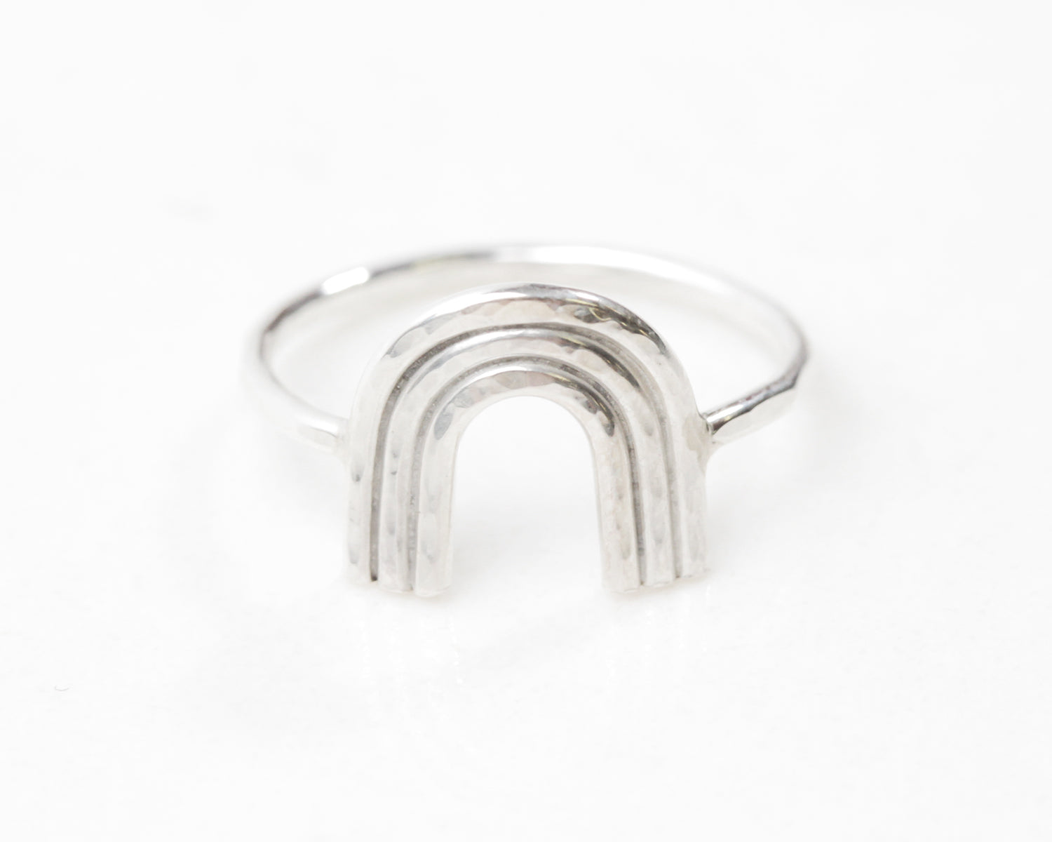 Photo shows the close up of our all sterling silver mini rainbow ring. Three pieces of sterling wire form the arches of the delicate and meaningful rainbow. Great gift to give or gift for self, this sweet mini ring comes in all US Ring sizes.