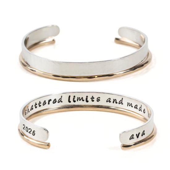 a silver and gold bracelet with the engraved inscription " shattered limits and made" on it.