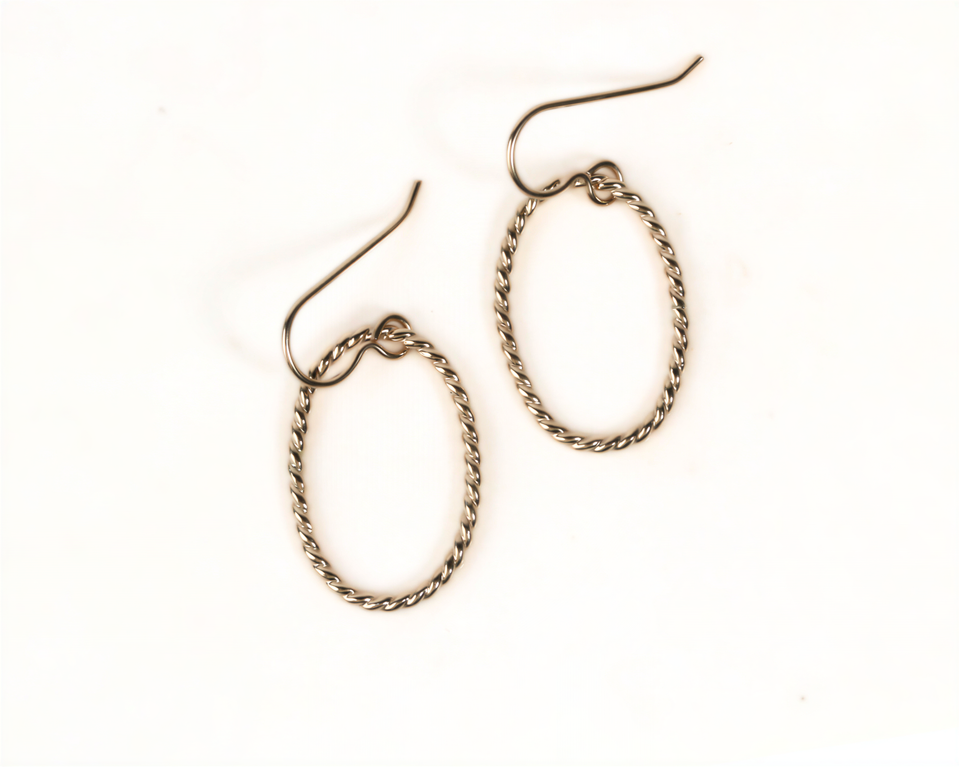 A pair of gold-colored earrings with twisted metal designs.