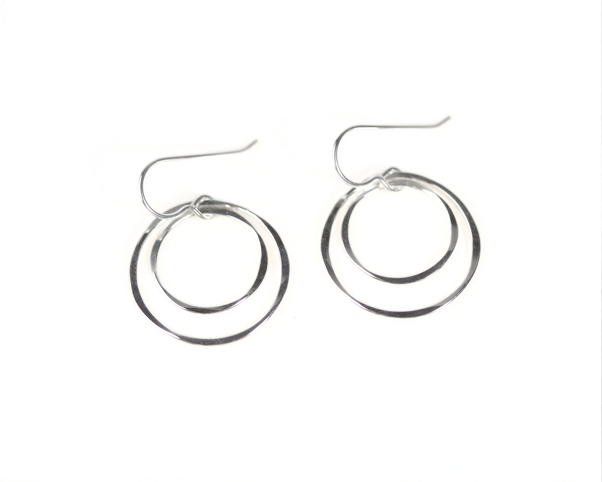 A pair of silver hoop earrings with a circular design, featuring two concentric circles connected by a thin metal hook.