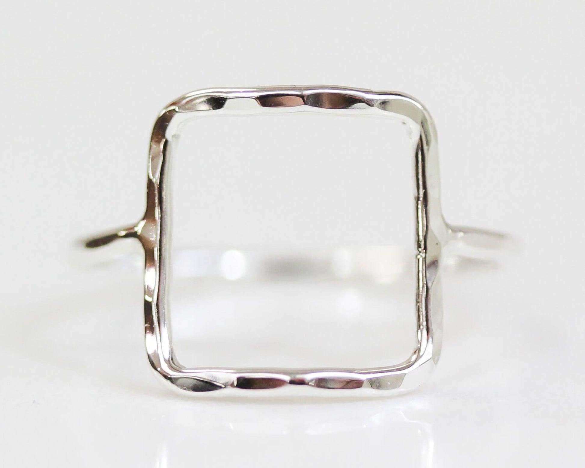 A simple silver ring with a square-shaped frame.