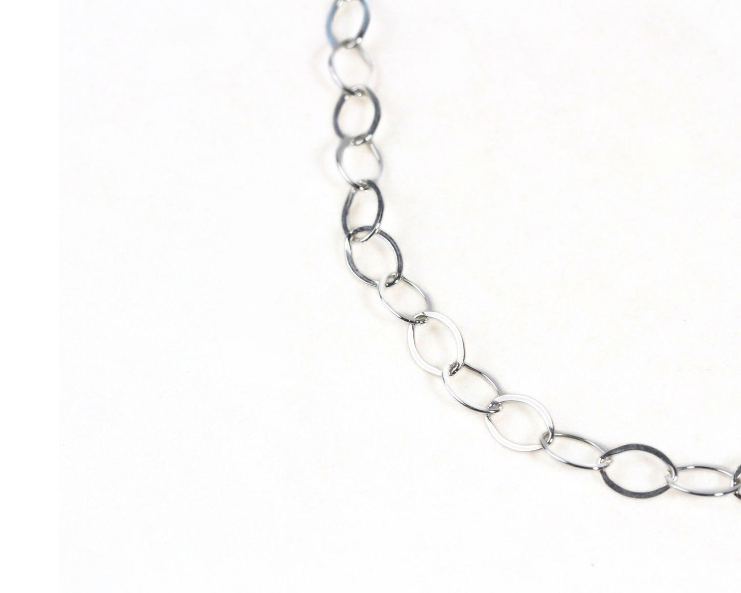 A silver chain necklace with multiple circular links.