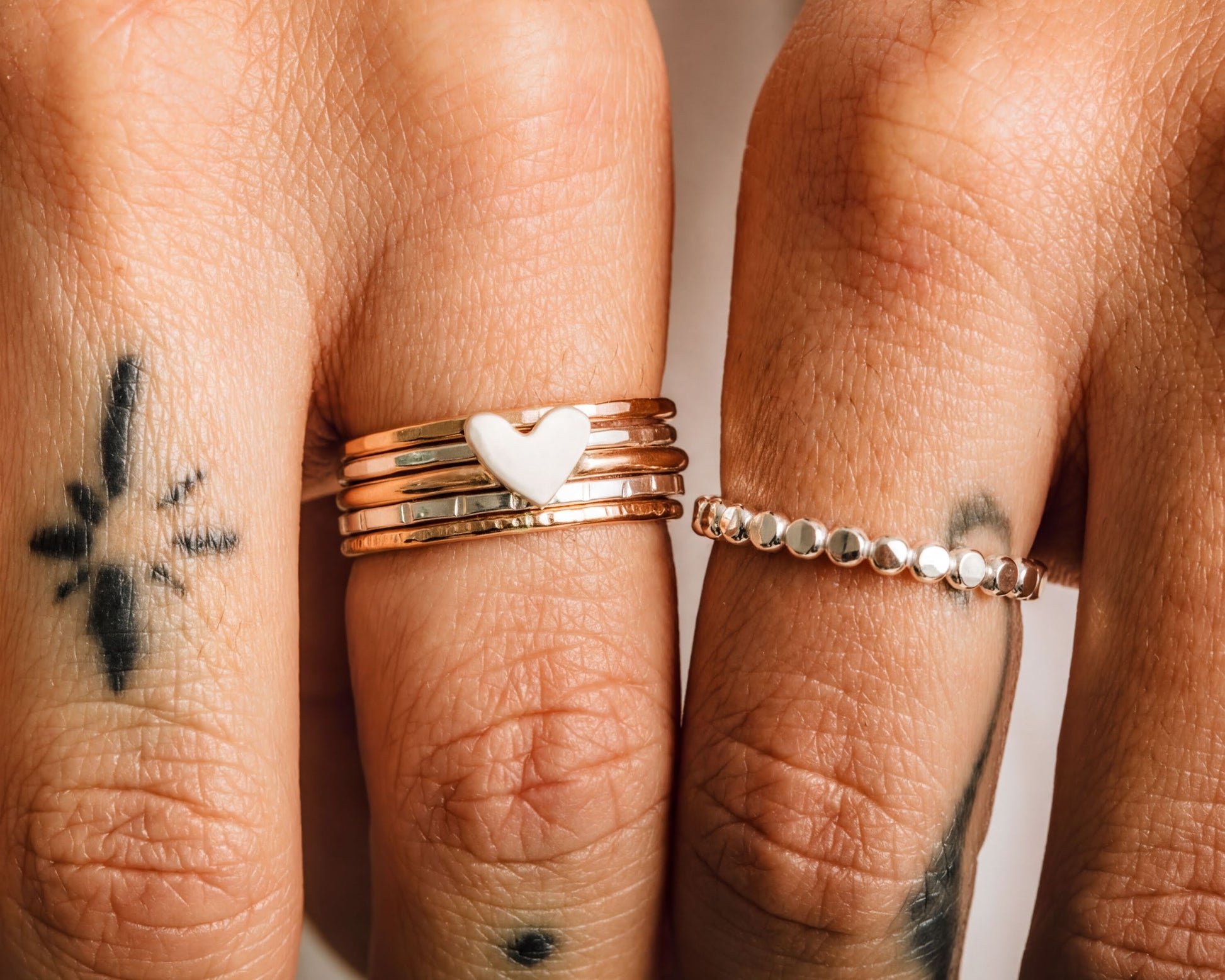 a close-up view of two hands wearing multiple rings on the fingers.