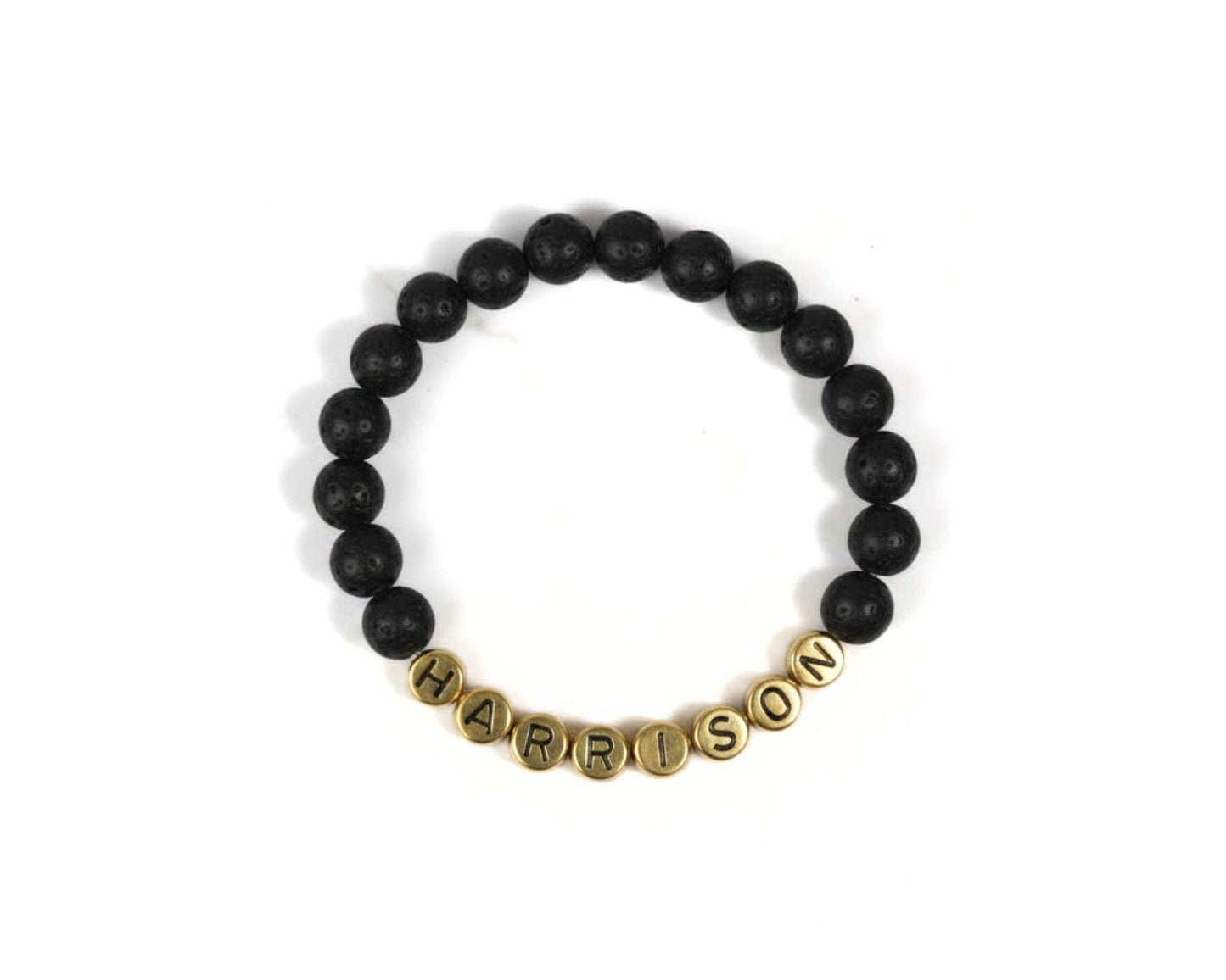 A bracelet made of black beads with the name "HARRISON" spelled out in gold letters.