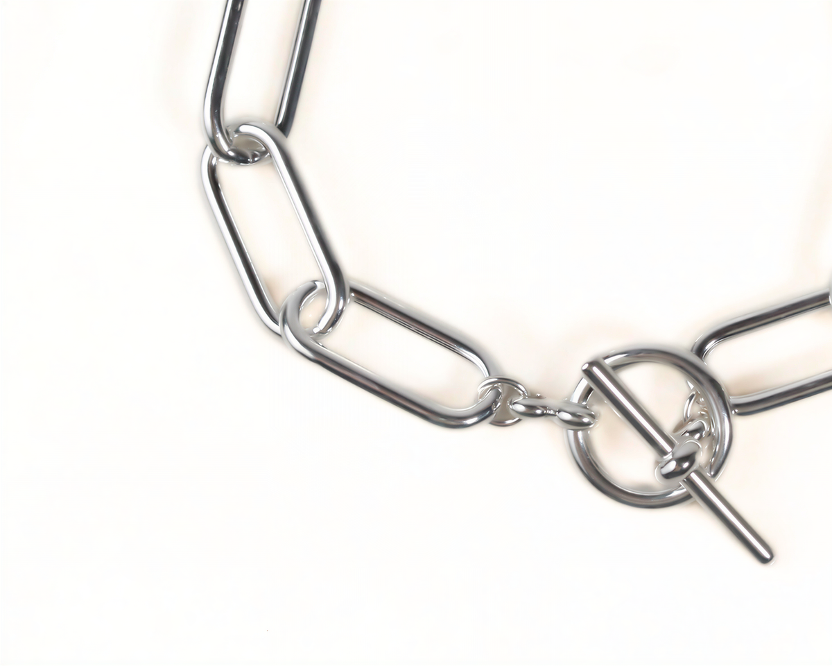 A close-up view of a silver-colored metal chain with interlocking links, suggesting a clasp or connector mechanism.